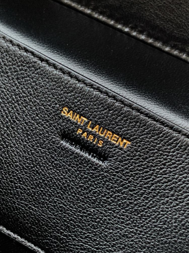 This is a quilted vanity-style handbag from Yves Saint Laurent (YSL), crafted in smooth black leather with a gold-tone brand logo and detachable strap. It exudes an elegant handheld feel and the convenience of shoulder carrying.