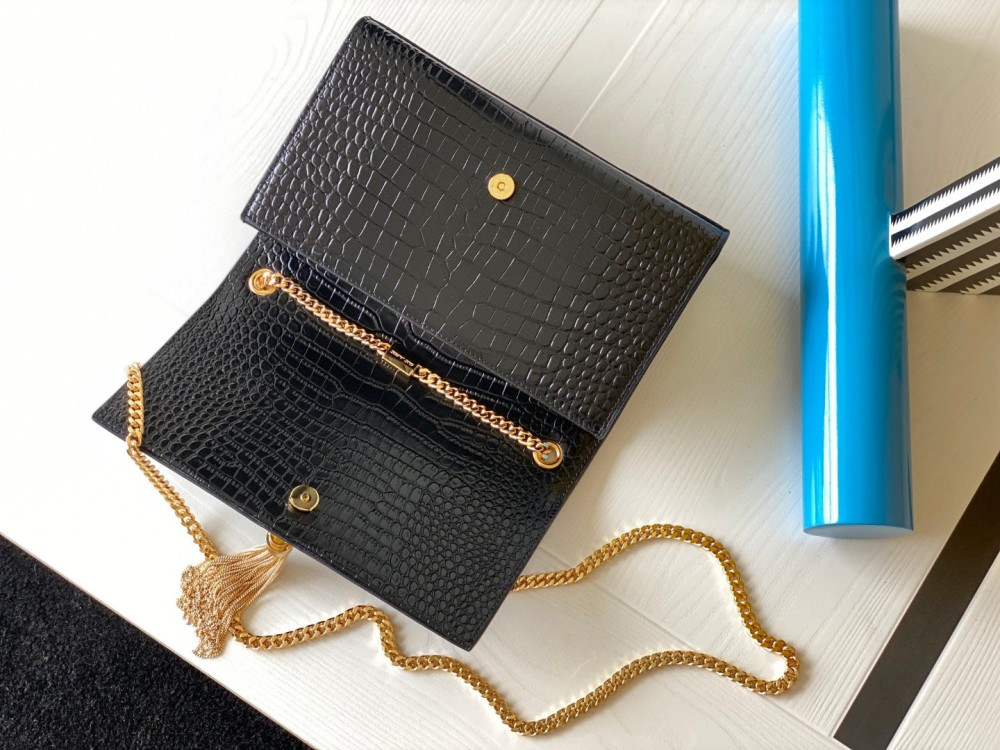 This is the YSL Kate tassel chain bag, made of black crocodile-embossed leather with gold-tone logo and tassel, suitable for shoulder or crossbody wear.