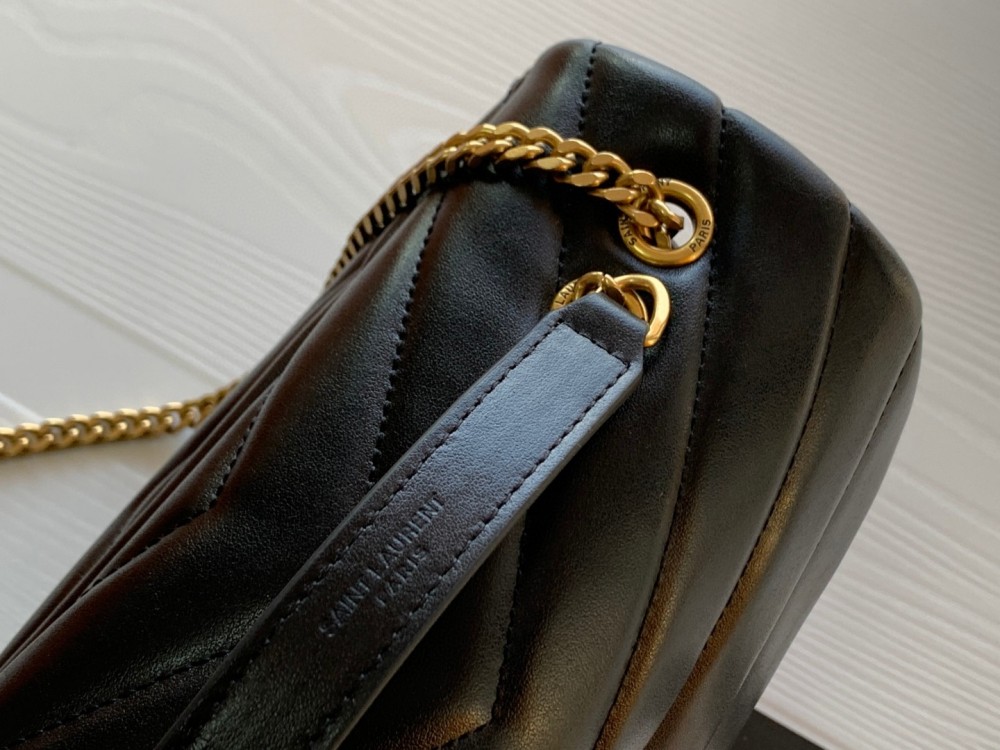 This is the YSL Loulou quilted bag, crafted from black lambskin leather with a gold-tone metal YSL logo and chain. It can be worn as a shoulder, crossbody, or top-handle bag, boasting a sophisticated and versatile style.
