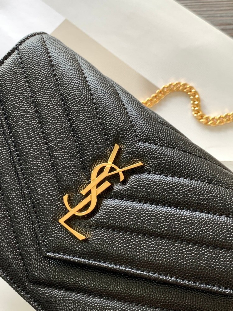 This is the YSL Cassandre chain wallet, crafted from black grained leather with quilted detailing and a gold-tone metal YSL logo on the front. It can be worn as a shoulder or crossbody bag, combining practicality with brand recognition.