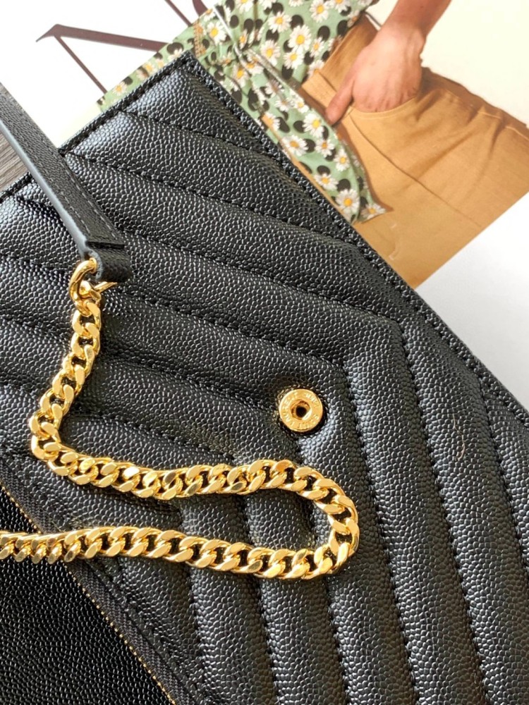 This is the YSL Cassandre chain wallet, crafted from black grained leather with quilted detailing and a gold-tone metal YSL logo on the front. It can be worn as a shoulder or crossbody bag, combining practicality with brand recognition.