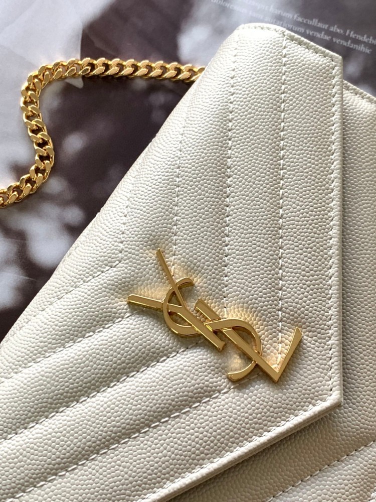 This is the YSL Cassandre chain wallet, crafted from white grained leather with quilted detailing and a gold-tone metal YSL logo on the front. It can be worn as a shoulder or crossbody bag, combining practicality with brand recognition.