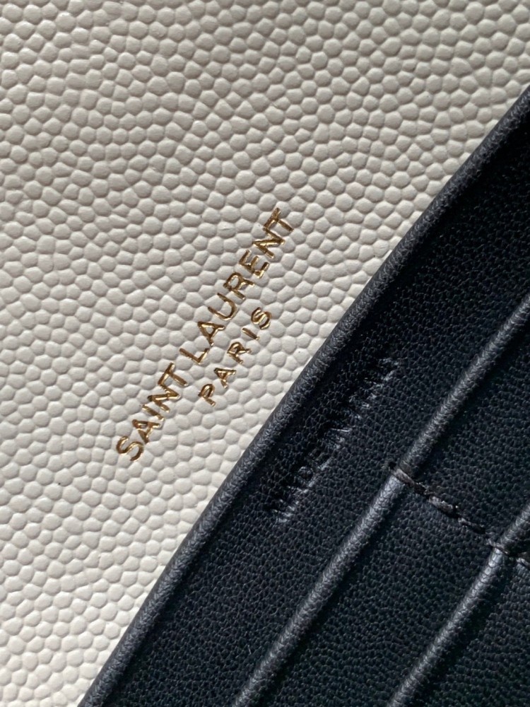 This is the YSL Cassandre chain wallet, crafted from white grained leather with quilted detailing and a gold-tone metal YSL logo on the front. It can be worn as a shoulder or crossbody bag, combining practicality with brand recognition.