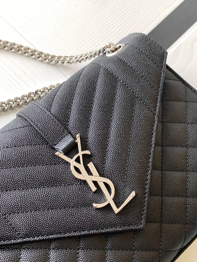 This is the YSL Envelope chain bag, crafted from black grained quilted leather with a silver-tone metal YSL logo, suitable for shoulder or crossbody wear.