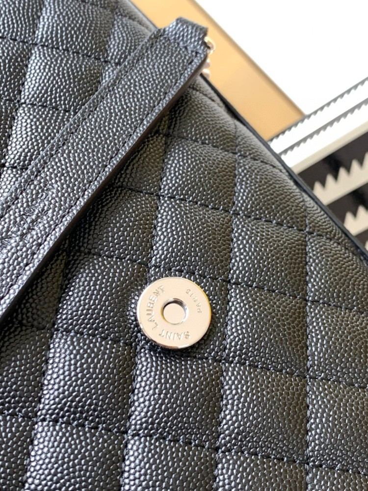 This is the YSL Envelope chain bag, crafted from black grained quilted leather with a silver-tone metal YSL logo, suitable for shoulder or crossbody wear.