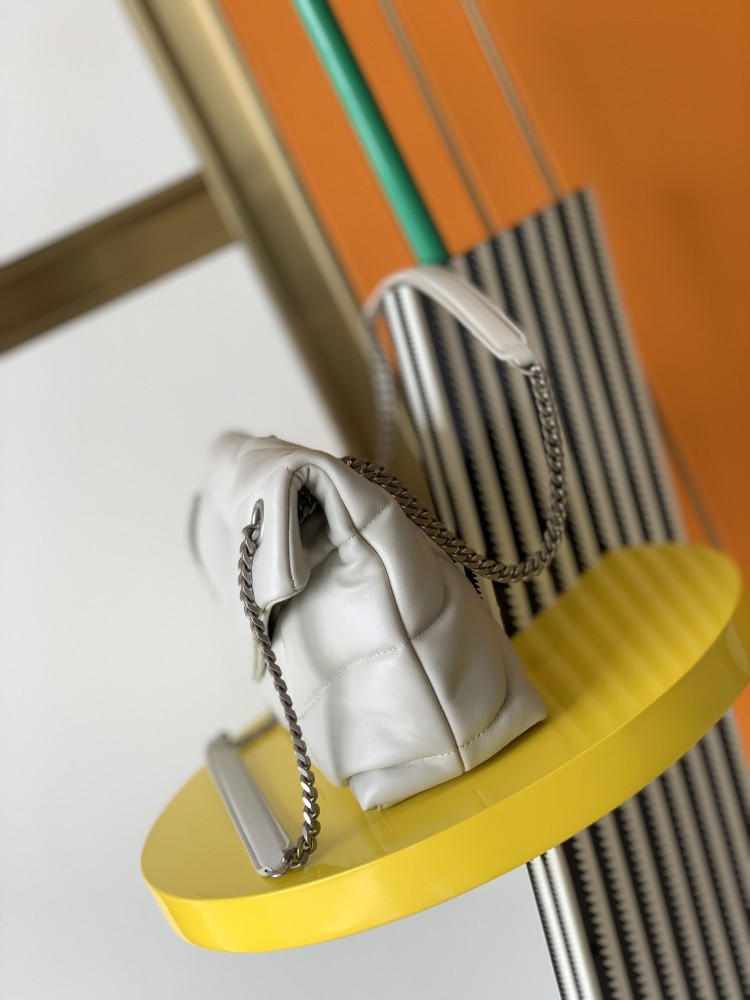 This is the YSL Loulou Puffer quilted bag, crafted from white soft leather with a silver YSL logo, featuring a relaxed yet sophisticated style and suitable for shoulder or crossbody wear.