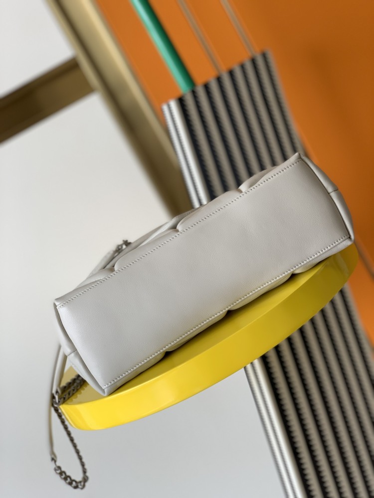 This is the YSL Loulou Puffer quilted bag, crafted from white soft leather with a silver YSL logo, featuring a relaxed yet sophisticated style and suitable for shoulder or crossbody wear.