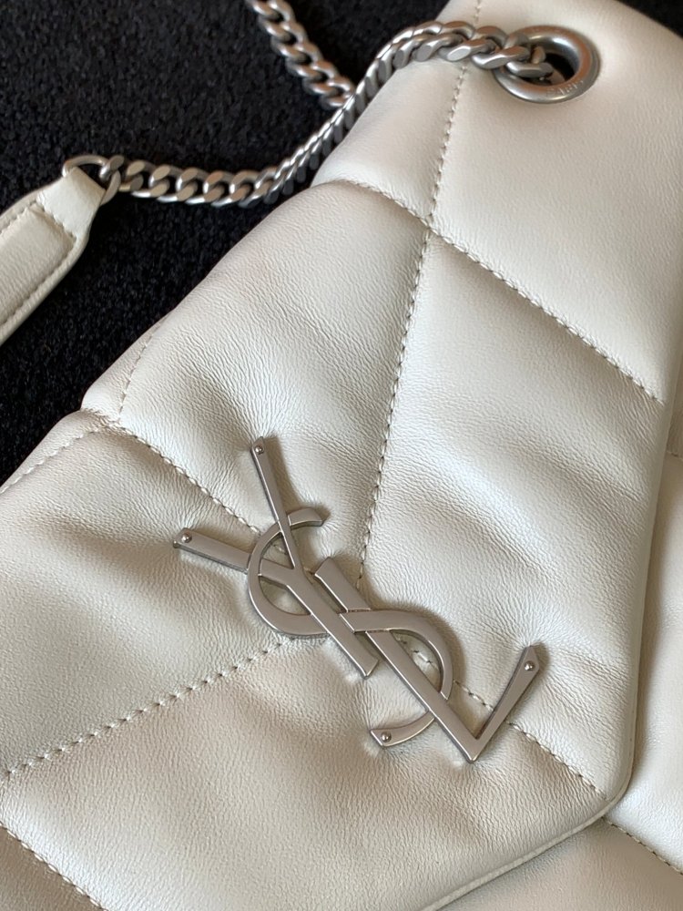 This is the YSL Loulou Puffer quilted bag, crafted from white soft leather with a silver YSL logo, featuring a relaxed yet sophisticated style and suitable for shoulder or crossbody wear.