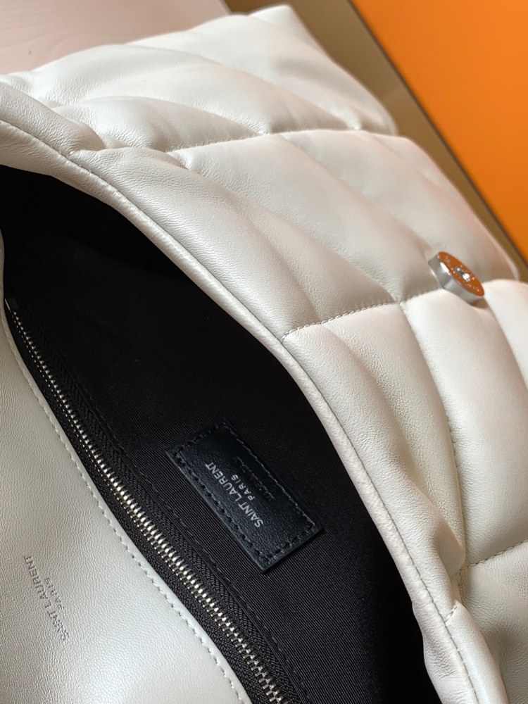 This is the YSL Loulou Puffer quilted bag, crafted from white soft leather with a silver YSL logo, featuring a relaxed yet sophisticated style and suitable for shoulder or crossbody wear.
