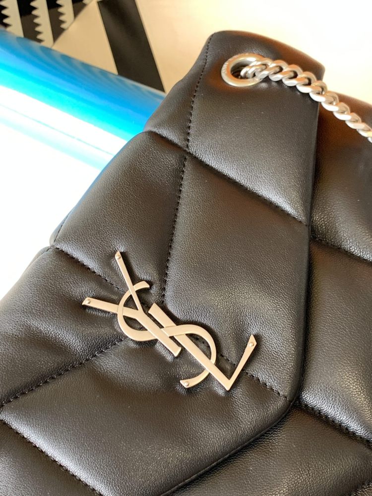This is the YSL Loulou Puffer quilted bag, crafted from black soft leather with a silver YSL logo, featuring a relaxed yet sophisticated style and suitable for shoulder or crossbody wear.