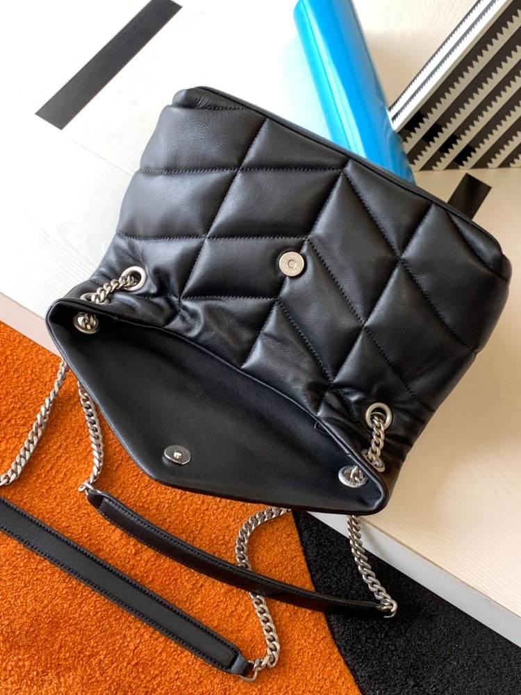 This is the YSL Loulou Puffer quilted bag, crafted from black soft leather with a silver YSL logo, featuring a relaxed yet sophisticated style and suitable for shoulder or crossbody wear.