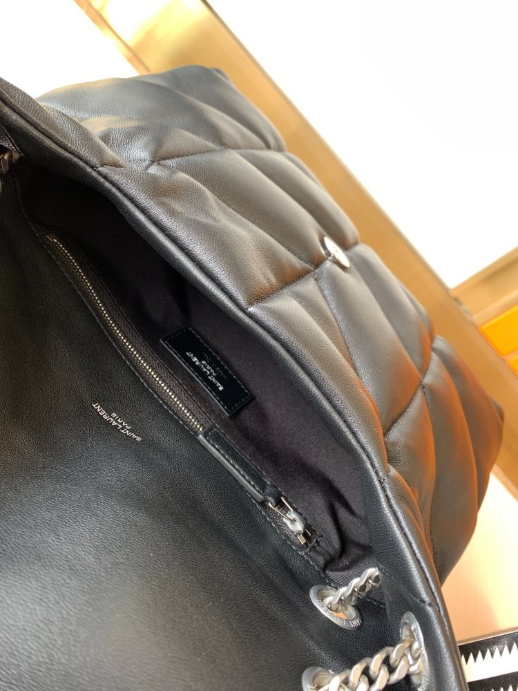 This is the YSL Loulou Puffer quilted bag, crafted from black soft leather with a silver YSL logo, featuring a relaxed yet sophisticated style and suitable for shoulder or crossbody wear.