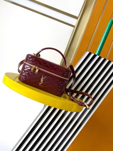 This is the YSL burgundy patent leather vanity bag with quilted stitching, featuring a top handle and crossbody strap.