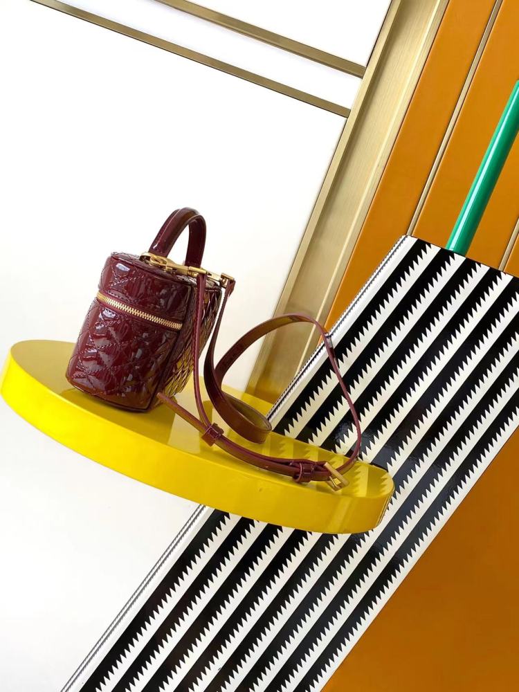 This is the YSL burgundy patent leather vanity bag with quilted stitching, featuring a top handle and crossbody strap.