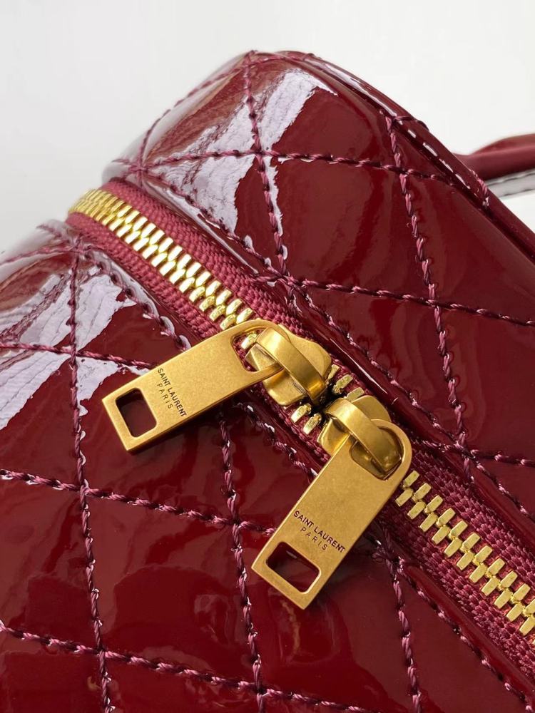 This is the YSL burgundy patent leather vanity bag with quilted stitching, featuring a top handle and crossbody strap.