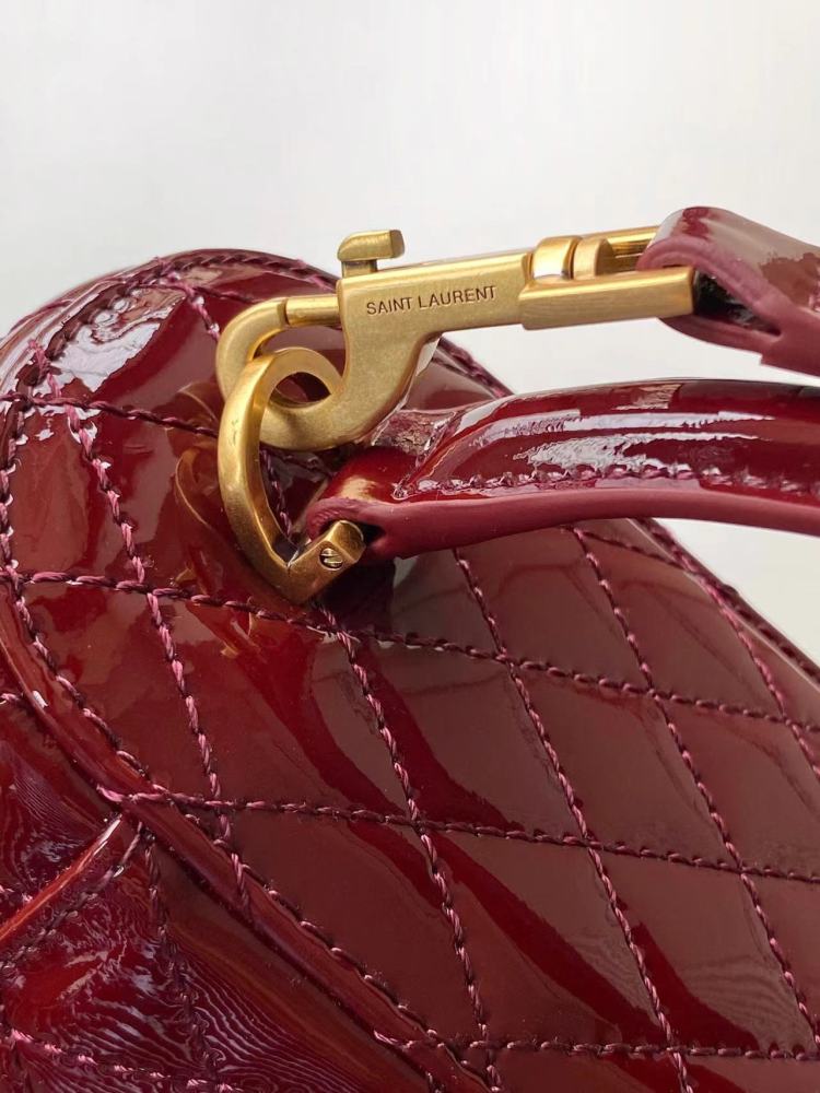 This is the YSL burgundy patent leather vanity bag with quilted stitching, featuring a top handle and crossbody strap.