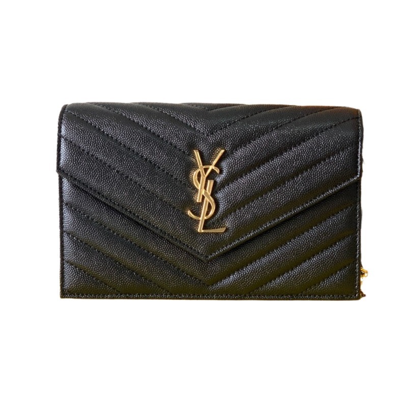 This is the YSL Cassandre chain wallet, crafted from black grained leather with quilted detailing and a gold-tone metal YSL logo on the front. It can be worn as a shoulder or crossbody bag, combining practicality with brand recognition.
