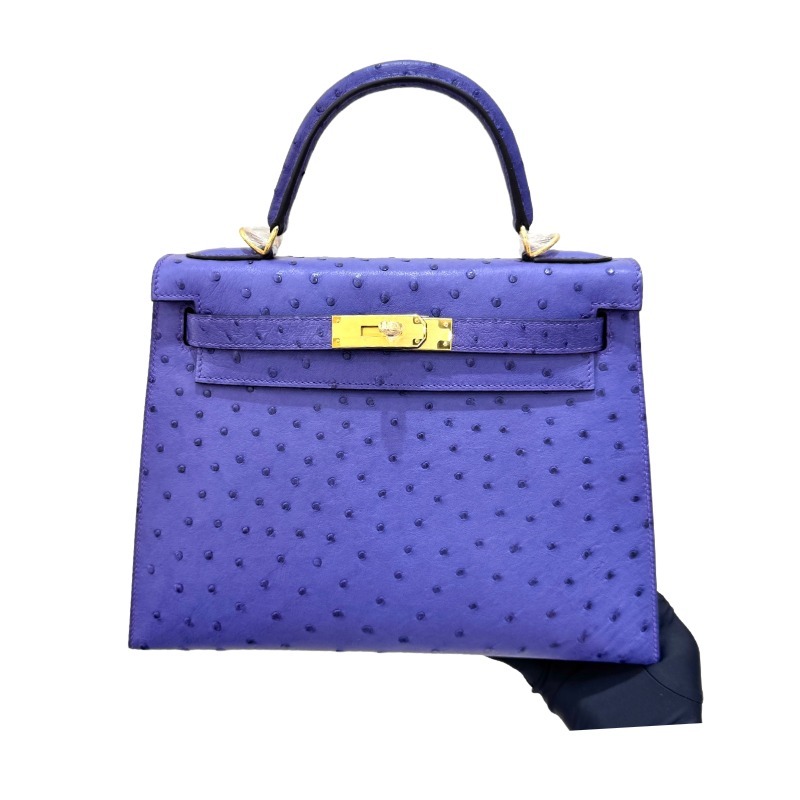 The Hermès Kelly 25 handbag in ostrich leather—rendered in a deep marine blue (gemstone blue / midnight blue) and accented with gold hardware—stands as a quintessential example of understated luxury among Hermès' exotic skins.