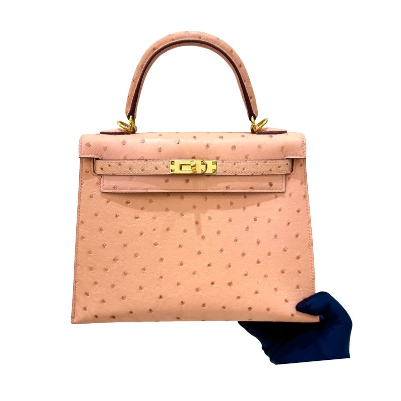 The Hermès Kelly 25 handbag in Ostrich leather—featuring a soft "Sakura Pink" hue (also known as "Nude Pink" or "Baby Pink") paired with gold hardware—is a highly sought-after model among Hermès exotic skins, perfectly blending a youthful, girlish charm w
