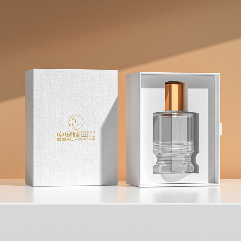White perfume drawer box with textured paper and gold logo, displayed beside an open box holding a clear perfume bottle.