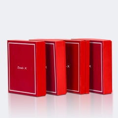 Closed red cosmetic gift boxes standing upright in a row, featuring white border artwork on the lids