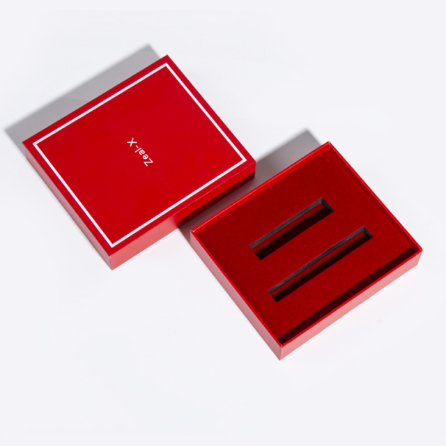Red makeup gift box with the lid removed to reveal two long rectangular insert slots