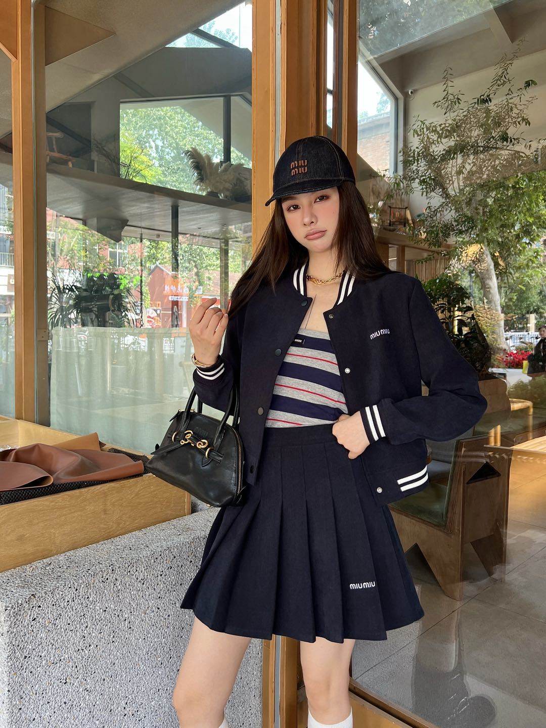 Cropped baseball jacket + high‑waist pleated midi skirt., Cailan (Chongqing) International Trading Co., Ltd,Cropped baseball jacket + high‑waist pleated midi skirt.- Cailan (Chongqing) International Trading Co., Ltd