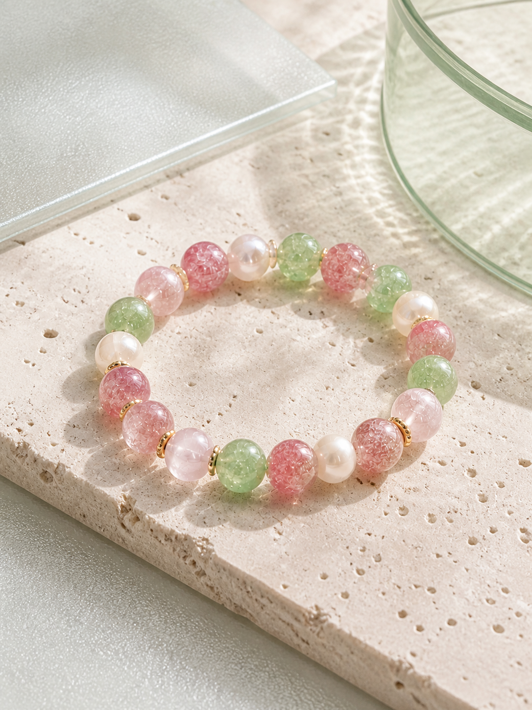 A pale green, pink and pearl-toned beaded bracelet arranged in soft natural light