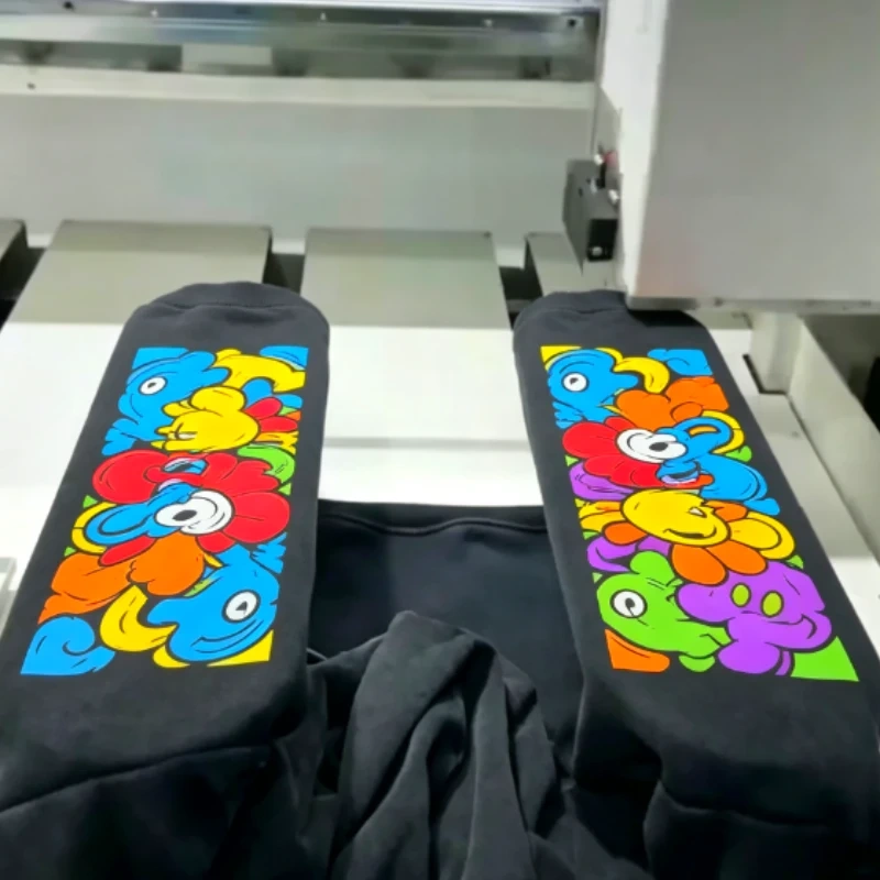 Cosmox Dual Table DTG Printer printing on black hoodie sleeves