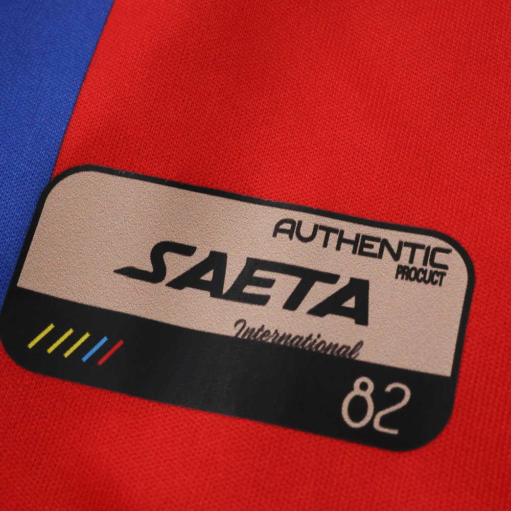 Close-up of the SAETA authentic product badge on the lower front of the Haiti 2026 second away jersey.