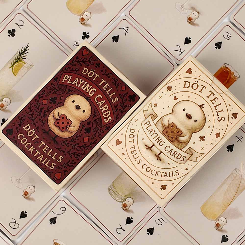 Two custom DOT TELLS playing card packaging variants side by side: cream coffee-bar tuck box and red cocktail tuck box with the cartoon bird mascot