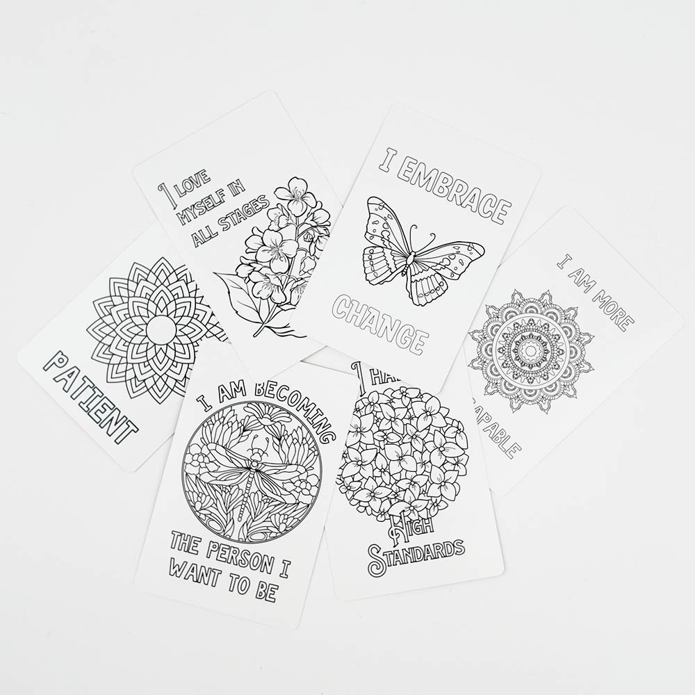 Rainbow gradient tuck box for Divine Declarations affirmation coloring cards placed on botanical line art cards