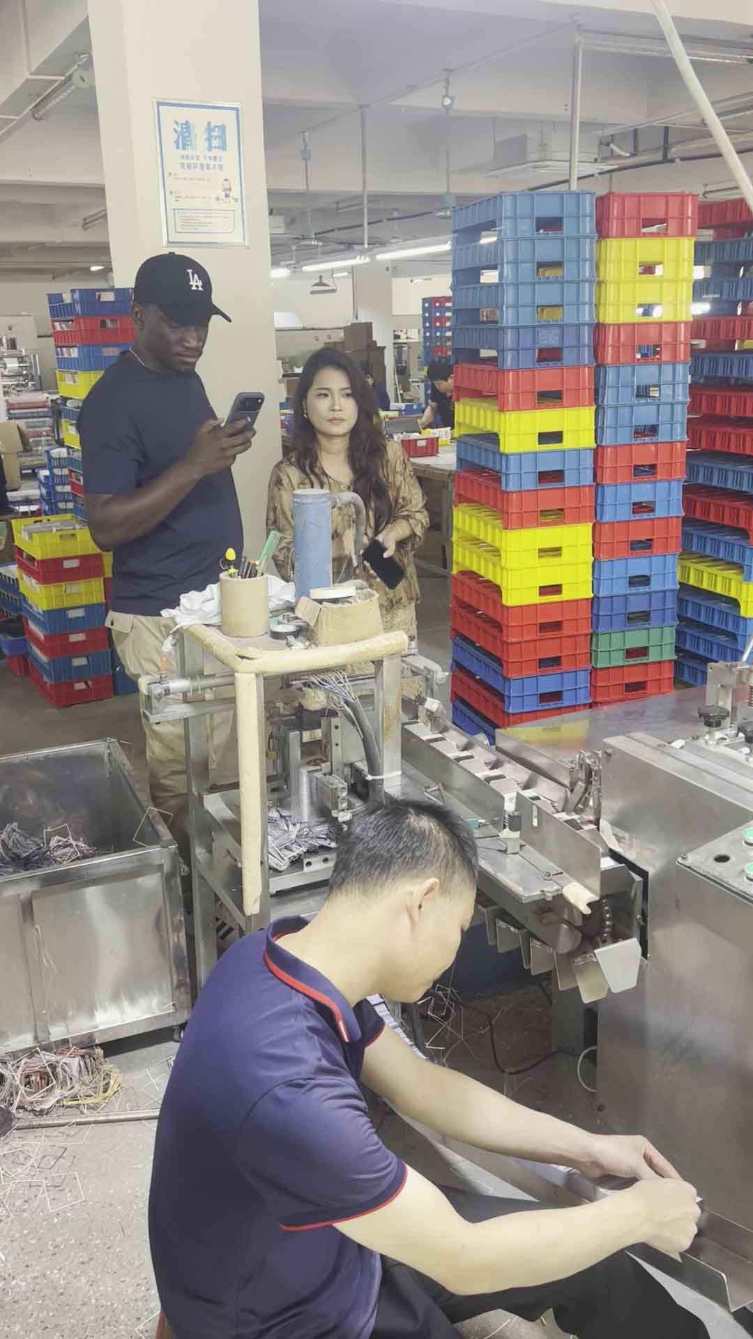 African client observing THRIWA card packing-line operations during a Guangzhou factory visit