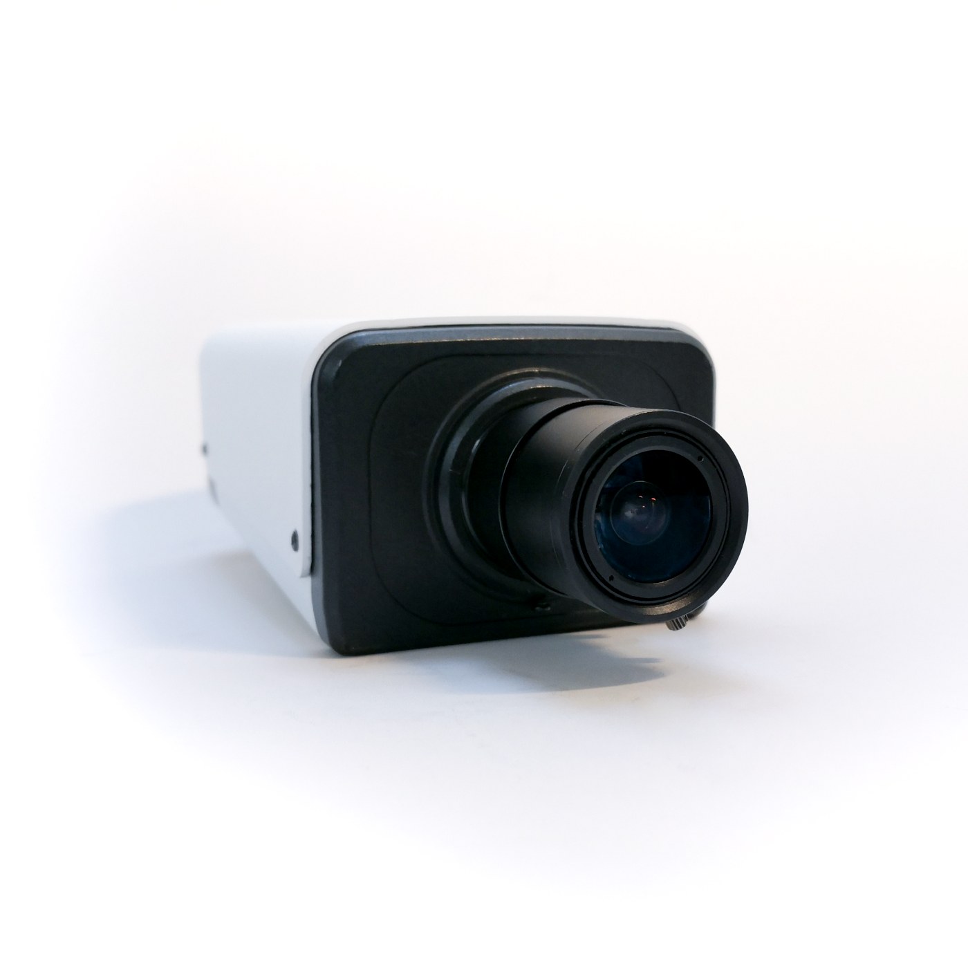 OpenNCC IPC camera in white bullet housing: angled front view with C-mount lens, running OpenVINO analytics on-device
